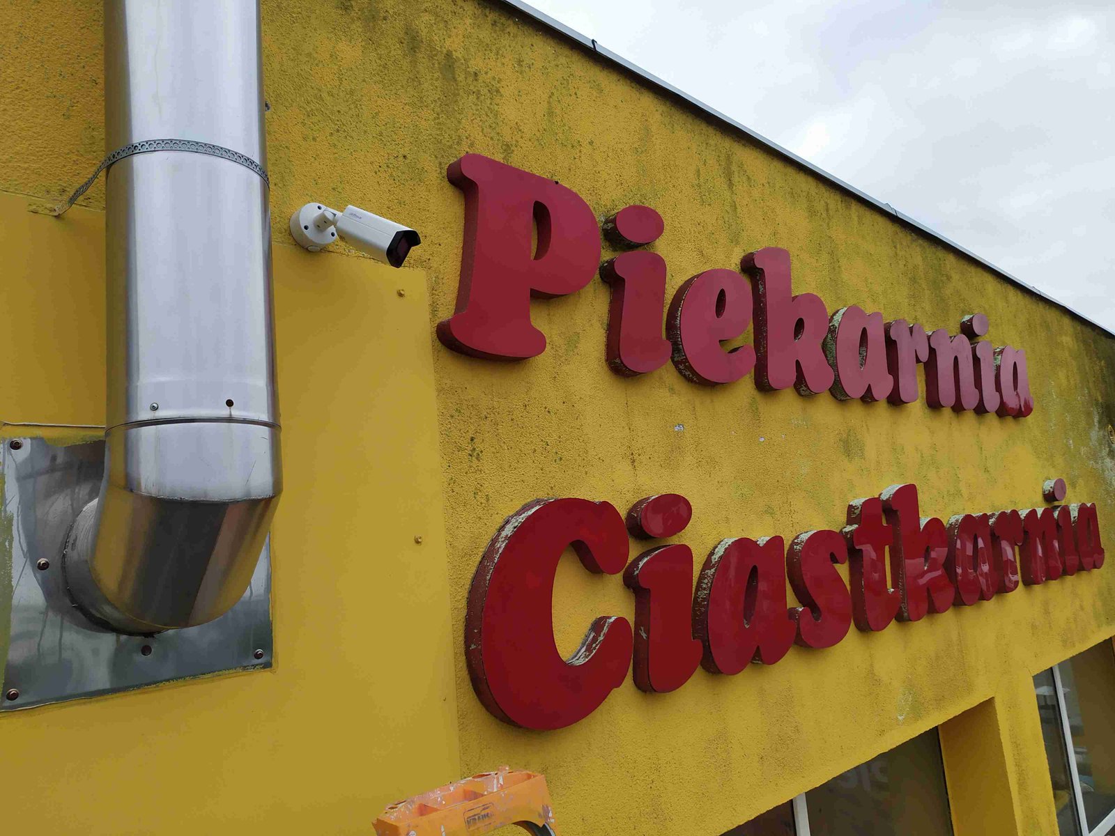 Kamera monitoringu Dahua na żółtej ścianie piekarni